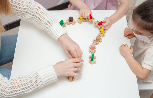 Two little girls in play constructs in the kindergarten. Little sisters play with a little train - Фото, зображення