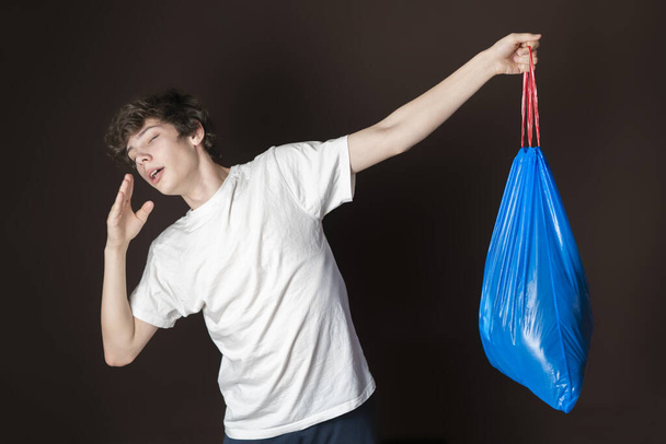 attrayant mâle tenir sac poubelle puant isolé. sortir la poubelle concept s - Photo, image