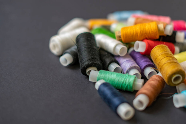Куча разноцветных нитей лежала на темном фоне изолированного d - Фото, изображение