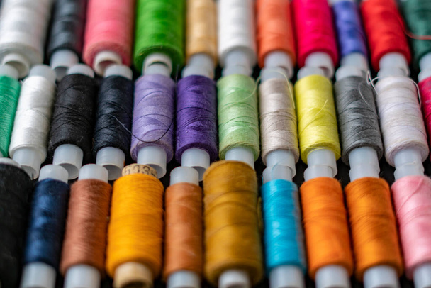 bunch of colorful sew threads lay on dark background isolated d - Zdjęcie, obraz