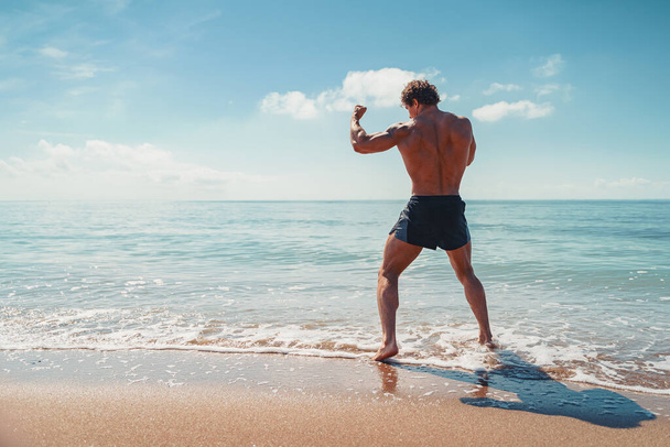 A muay thai or kickboxer training with shadow boxing outdoor at seashore - 写真・画像