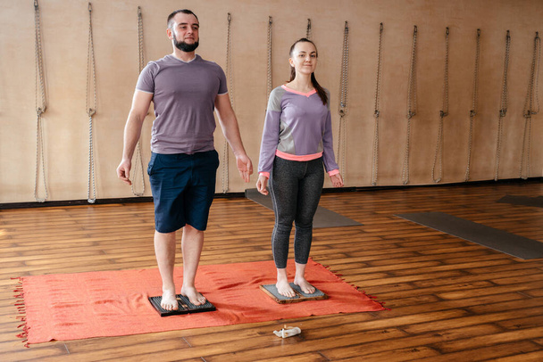 Man trainer leren vrouw om te staan op sadhu yoga board, blootsvoets op een bed van nagels - Foto, afbeelding