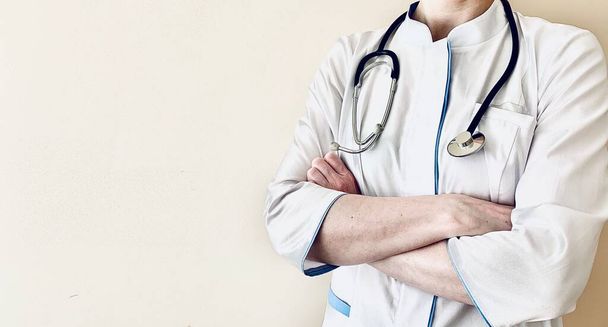 Doctor with stethoscope, arms crossed over his chest on a white background. Professional medical practice, doctor and healthcare concept. Medicine. Copy space. Place for your text. - Fotografie, Obrázek