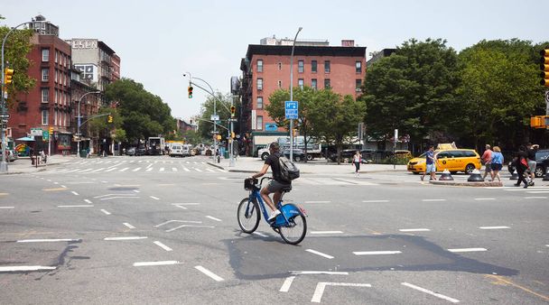 New York, États-Unis - 03 juillet 2018 : Un homme non identifié traverse Houston Street à vélo. - Photo, image