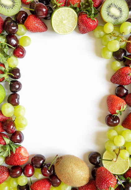 frame from juicy fruits with copy space. strawberries, cherries, kiwi and grapes on a white background. - Foto, imagen