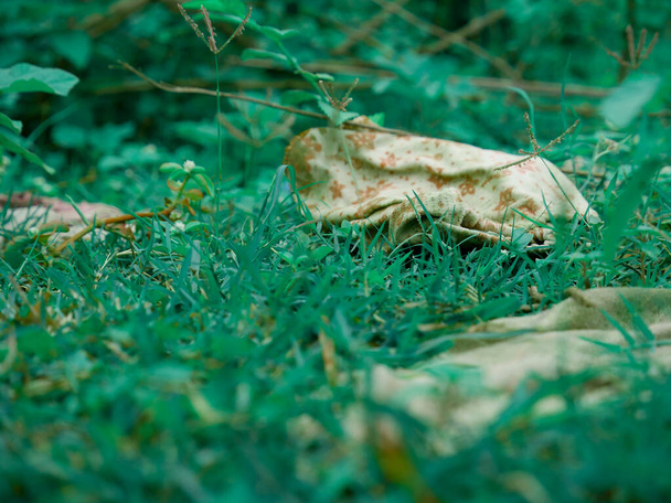 Colección de tela sucia alrededor del campo de hierba verde. - Foto, Imagen