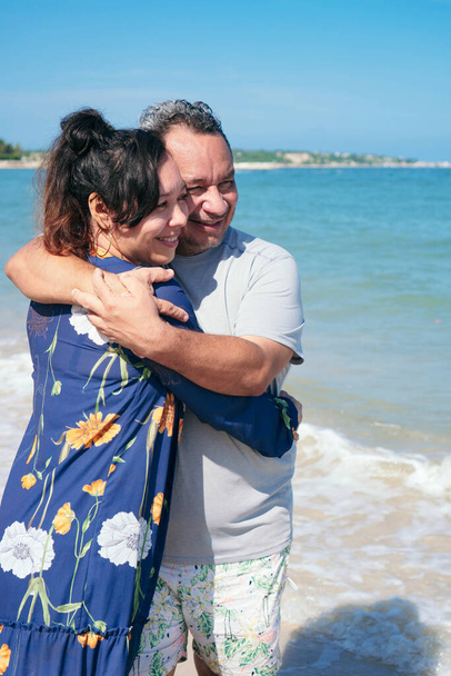 Älteres Latino-Paar kuschelt draußen am Wasser - Foto, Bild