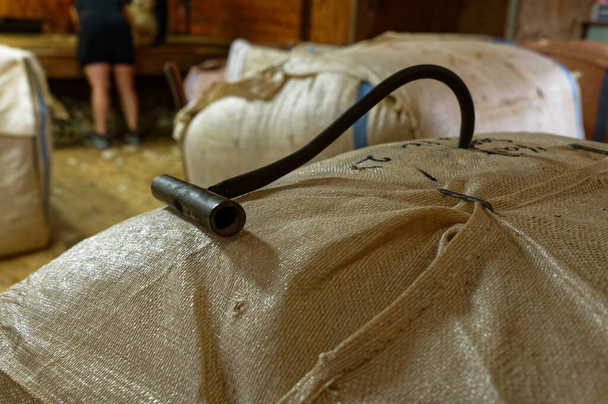 A black, metal wool bale hook is in a wool bale in a shearing shed - Foto, imagen