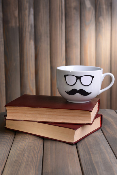 Cup with mustache on table on wooden background - Φωτογραφία, εικόνα