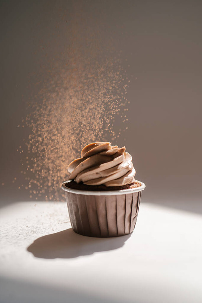 Cupcake on a dark background, which is sprinkled on top. - Valokuva, kuva
