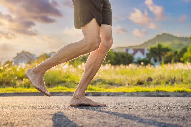 A man runner is engaged in jogging on the asphalt without shoes, without sneakers, for health - Φωτογραφία, εικόνα