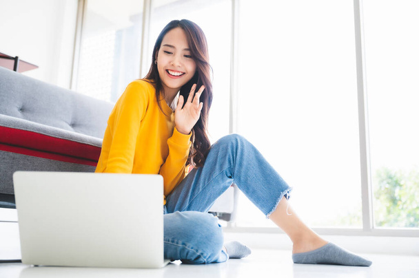 Beautiful young asian woman sitting on the floor working using computer laptop feeling happy relax and smile - Foto, afbeelding
