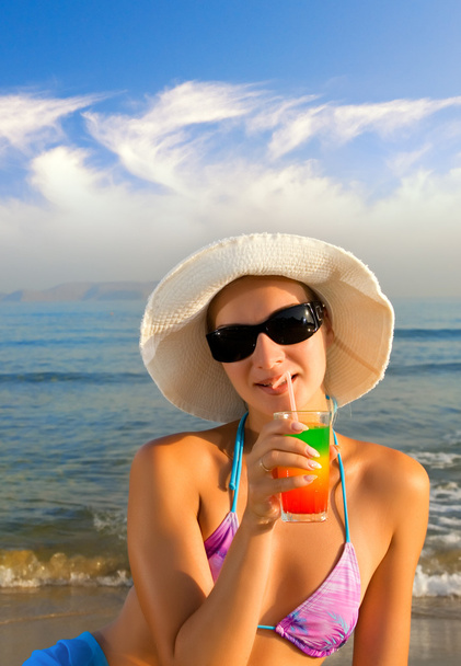Beautiful girl drinking fruit cocktail on the beach - Fotó, kép