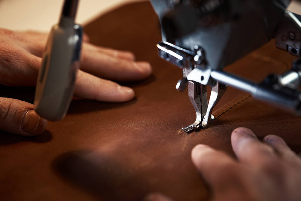 Leatherworker workflow. A tanner or skinner sews leather on a special sewing machine. A worker sews on a sewing machine, first-person view. - Fotografie, Obrázek
