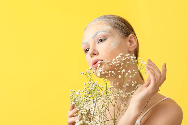 Mulher bonita com sobrancelhas tingidas e flores no fundo de cor - Foto, Imagem