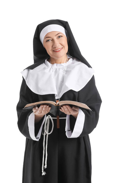 Dojrzała zakonnica z Pismem Świętym na białym tle - Zdjęcie, obraz
