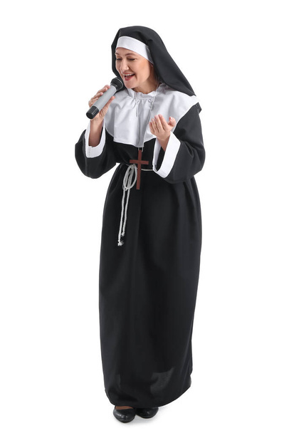 Ältere Nonne mit Mikrofon auf weißem Hintergrund - Foto, Bild