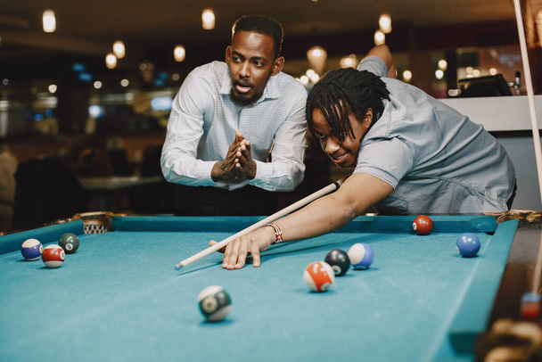Men playing billiards in a club - Fotó, kép