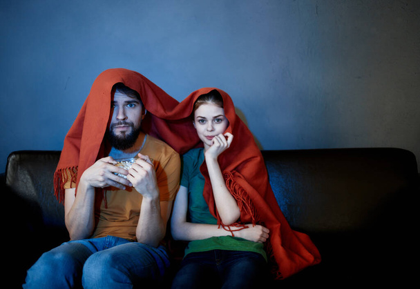 結婚した夫婦がテレビの前の毛布で覆われたソファで離陸し - 写真・画像