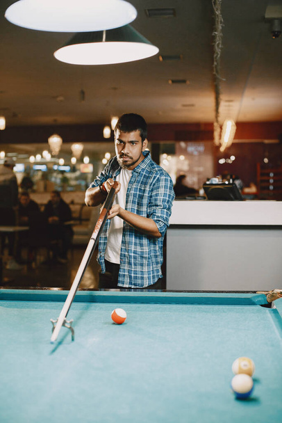 Man playing billiards in a club - Foto, afbeelding