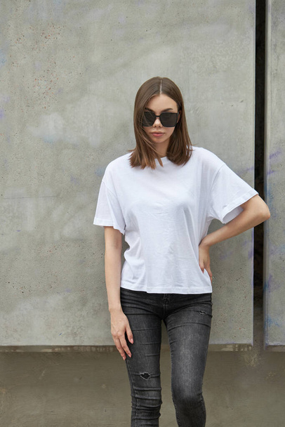Girl or woman wearing white blank t-shirt with space for your logo, mock up or design in casual urban style - 写真・画像