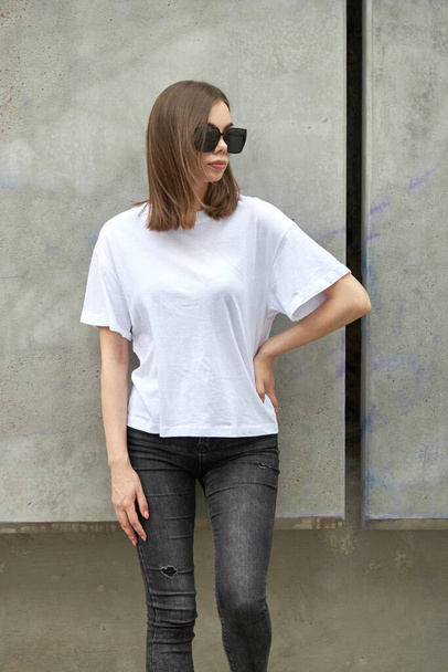 Girl or woman wearing white blank t-shirt with space for your logo, mock up or design in casual urban style - Φωτογραφία, εικόνα
