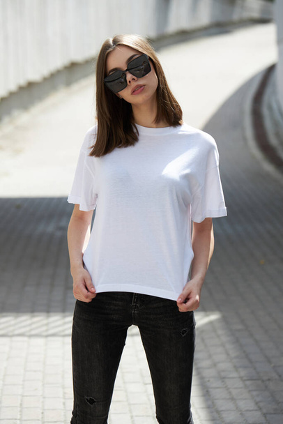 Girl or woman wearing white blank t-shirt with space for your logo, mock up or design in casual urban style - Φωτογραφία, εικόνα