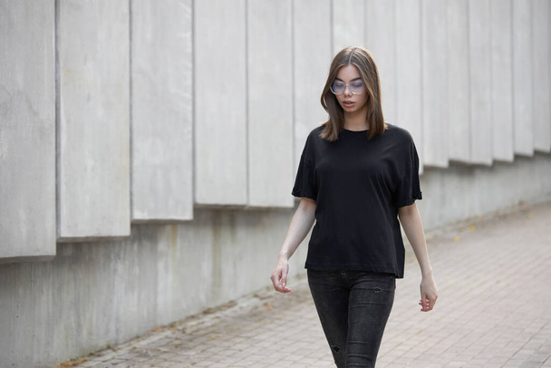 Žena nebo dívka v černém prázdném bavlněném tričku s prostorem pro vaše logo, modelovat nebo design v neformálním městském stylu - Fotografie, Obrázek
