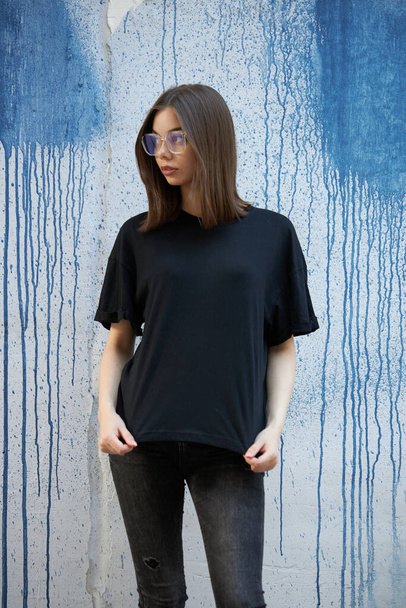Woman or girl wearing black blank cotton t-shirt with space for your logo, mock up or design in casual urban style - Foto, Imagem