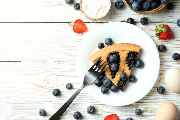 Concepto de delicioso postre con pastel de arándanos sobre mesa de madera blanca - Foto, imagen