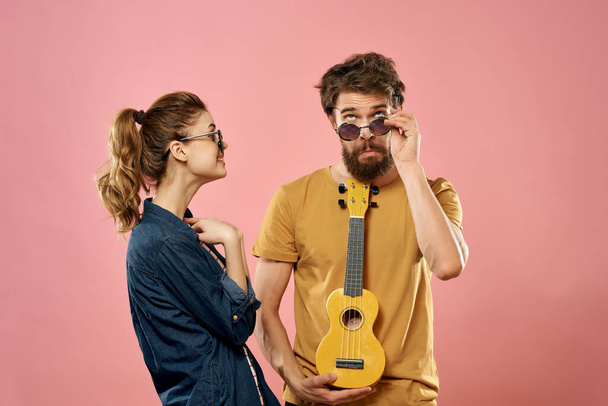 cheerful young couple ukulele pink background fun fashion - Фото, изображение
