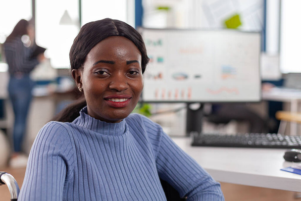 Gelukkig Afrikaans zakenvrouw met een handicap kijken naar camera glimlachen - Foto, afbeelding