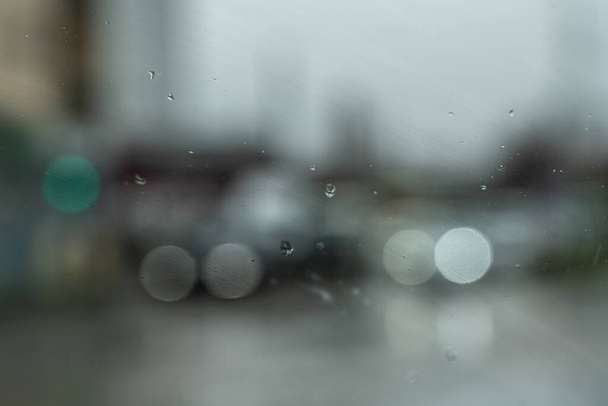 Autólámpák üvegen keresztül esőcseppekben - Fotó, kép
