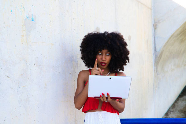 Gyönyörű afro-amerikai nő egy videokonferencián laptoppal. A nő jól érzi magát, miközben elmagyarázza, miről beszélnek. Telework koncepció. Videohívás - Fotó, kép