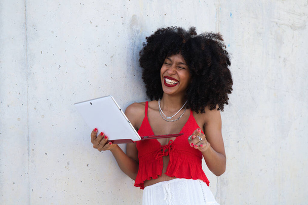 beautiful afro-american woman in a video conference with laptop. The woman is having fun while explaining what they are talking about. Telework concept. Video call - Photo, Image