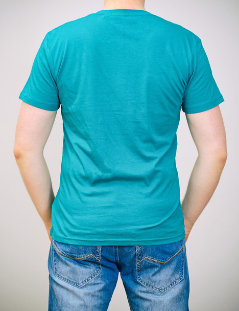 Homme en t-shirt turquoise. Fond gris
. - Photo, image