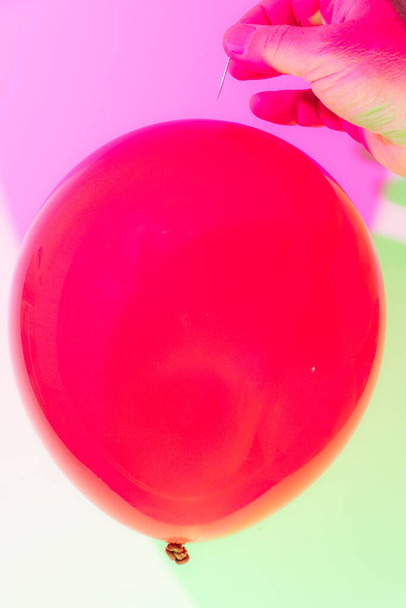 Ένα κόκκινο μπαλόνι παίρνει έσκασε από μια καρφίτσα. - Φωτογραφία, εικόνα