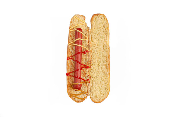 Hot dog ingredients. A cut bun contains the ingredients: sausage and sauce. View from above. White background. Isolated. - Фото, зображення