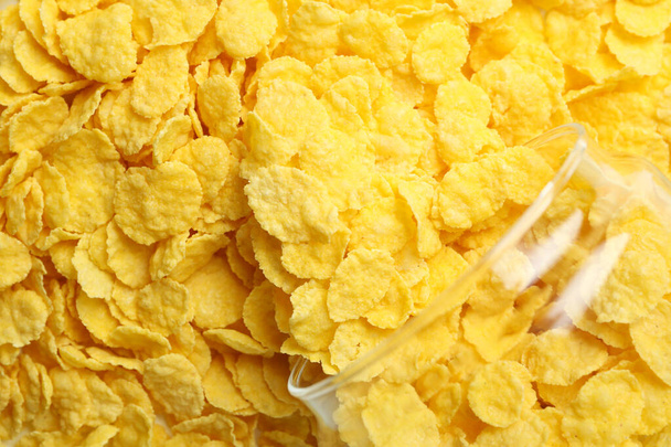 Jar with corn flakes on corn flakes background - Foto, afbeelding
