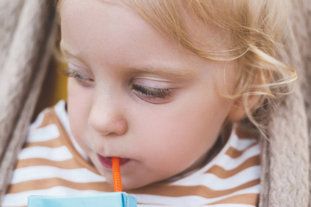 Close up little baby girl drinking with straw - Zdjęcie, obraz