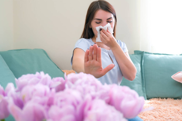 young woman sneezes from flower allergy. Pollen allergy - Fotó, kép