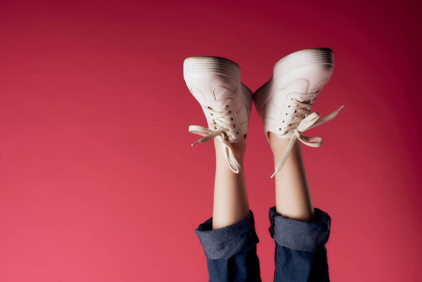 inverted female legs in white sneakers modern style isolated background - Photo, Image