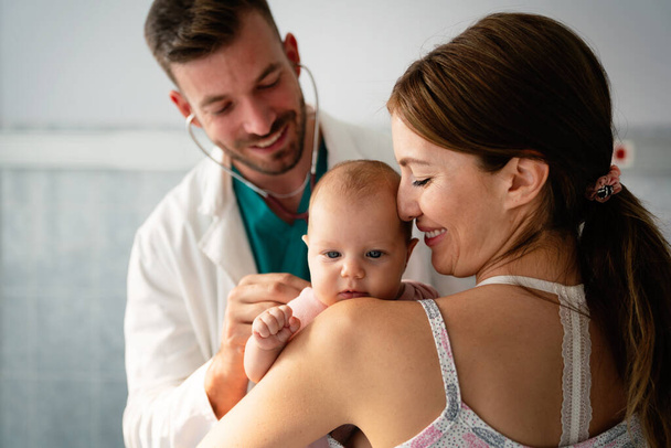 Mother holding baby for pediatrician doctor to examine. People healthcare concept - Foto, Imagen