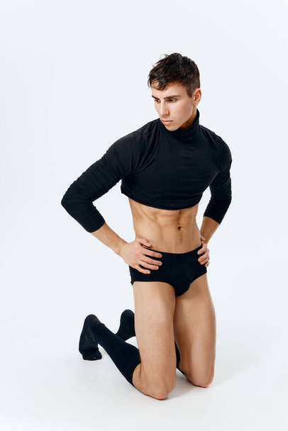 man with a pumped-up torso in shorts and in black socks posing  - Photo, image
