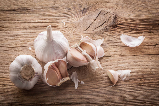 Garlic bulbs and cloves on wooden table, closeup - Photo, Image