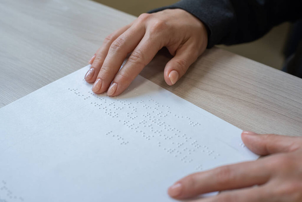 Close-up woman reads the text to the blind. Womans hands on paper with braille code. - Foto, Bild