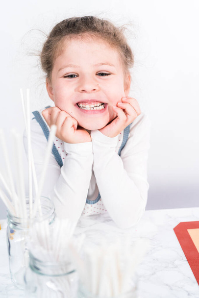 Маленька дівчинка допомагає робити льодяники цукерки з ягідними ароматами
. - Фото, зображення