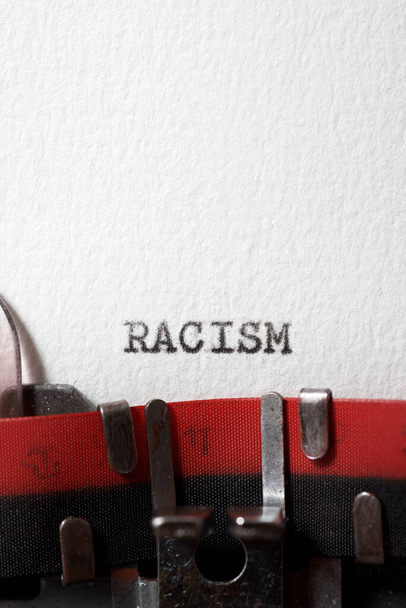 Η λέξη ρατσισμός γράφεται με μια γραφομηχανή. - Φωτογραφία, εικόνα