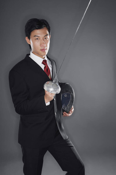 Businessman with a fencing foil and mask - Foto, afbeelding