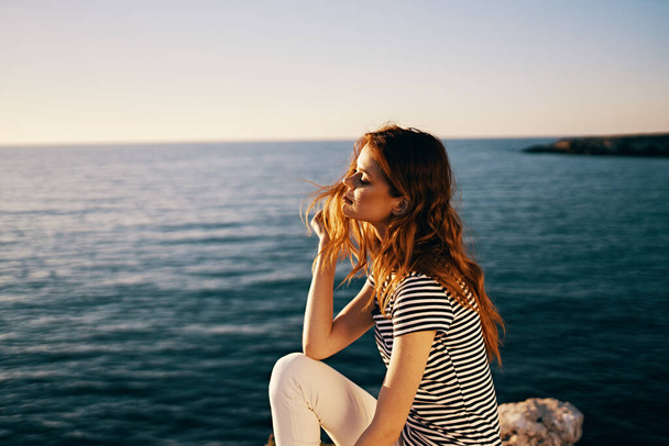 mooie vrouw bij de zee bij zonsondergang zomer t-shirt hemel - Foto, afbeelding